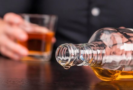 Бутылка алкоголя лежит на столе
